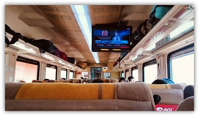 Tejas Express train advertising with headrest branding and overhead LED screen